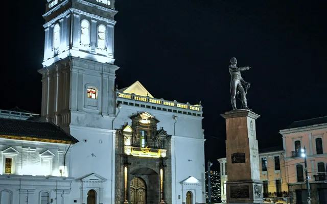 Plaza de Santo Domingo en Quito de noche, con la iglesia y el monumento iluminados